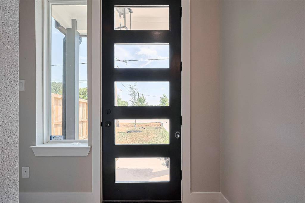 Welcoming Entry with Stylish Light and ViewsA continuation of modern elegance, this glass-paneled door welcomes you with natural light and a peek into the fully fenced yard. Framed by a tall picture window, this entryway balances privacy with openness—making your arrival feel warm, stylish, and secure.
