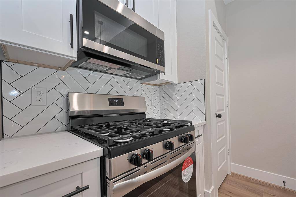 Premium Cooking Zone with Modern EdgeCook like a pro with this full stainless steel appliance package featuring a gas range, built-in microwave, and striking herringbone tile backsplash. Surrounded by quartz countertops and white shaker cabinetry, this corner is as stylish as it is functional—ready for weeknight meals or weekend feasts.