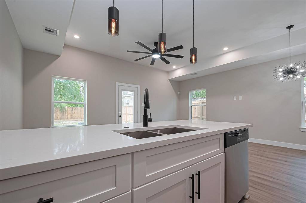 Centerpiece Island for Modern LivingFramed by pendant lights and open views of the living and dining areas, this oversized island does it all—meal prep, morning coffee, and entertaining with ease. Sleek black hardware, a deep stainless sink, and statement lighting elevate the space while maintaining effortless functionality.