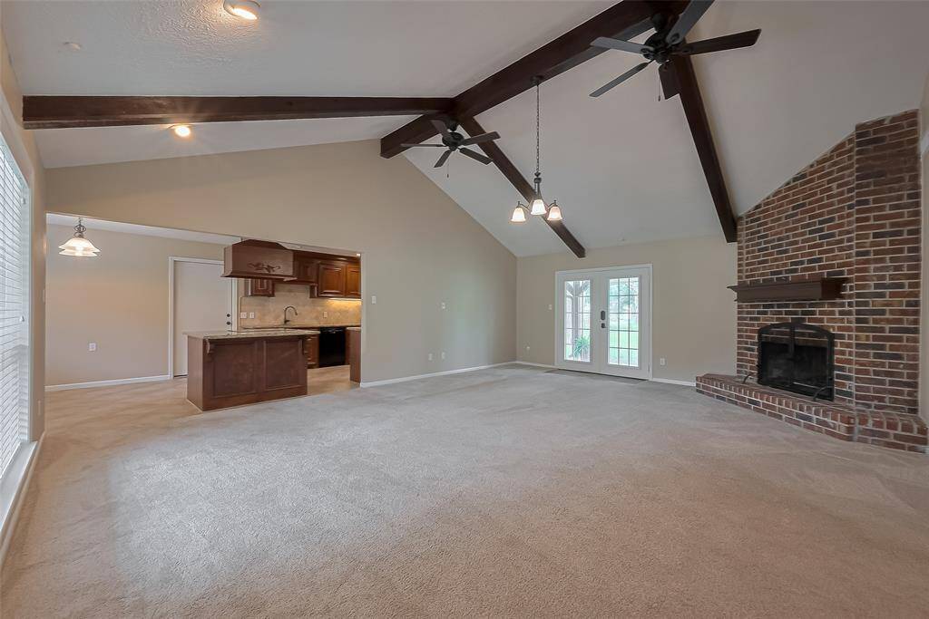 The large living area offers a wood burning fireplace, large wood beams and so many decorating options.