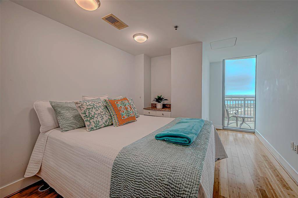 Experience tranquility in this secondary bedroom featuring a built-in desk, elegant bamboo flooring, and stunning bay views.