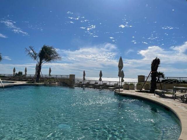 Enjoy year-round fitness and relaxation with a heated pool, perfect for water aerobics and swimming laps, set against a backdrop of clear skies and serene palm trees.