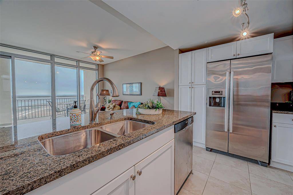 This kitchen boasts stunning granite countertops, abundant natural light, and breathtaking bay views.