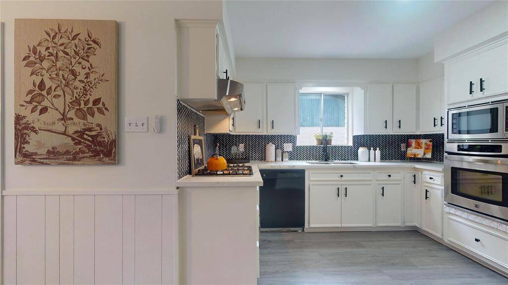The kitchen was remodeled recently - the contrast between the white cabinets, the quartz counter tops and the darker backsplash is so pleasing!