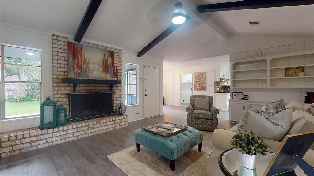 Beautiful living area with fireplace, built-ins, high, beamed ceilings, and lots of natural light!