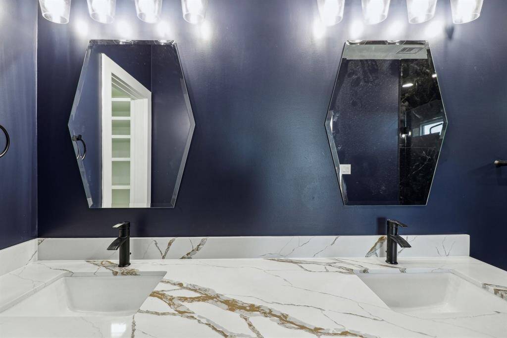 Quartz countertops with gorgeous mirrors enhancing the overall elegance and functionality of the bathroom