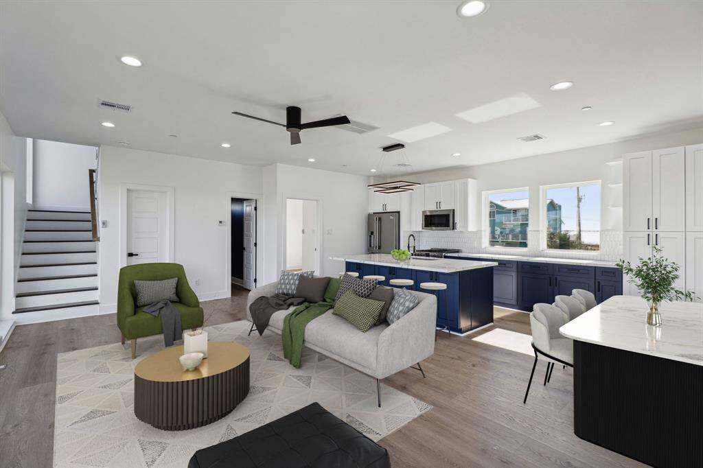 Open floor plan living seamlessly connecting the living room dining area and kitchen creating a bright and airy environment perfect for entertaining
