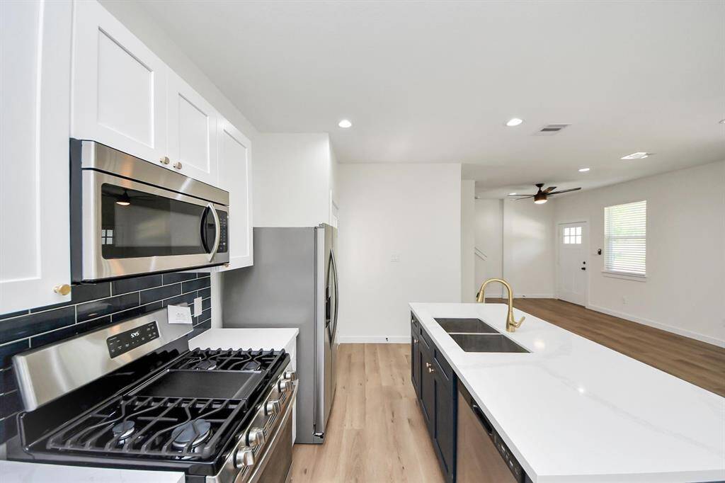 gas stove, stainless steel fridge and quartz countertops