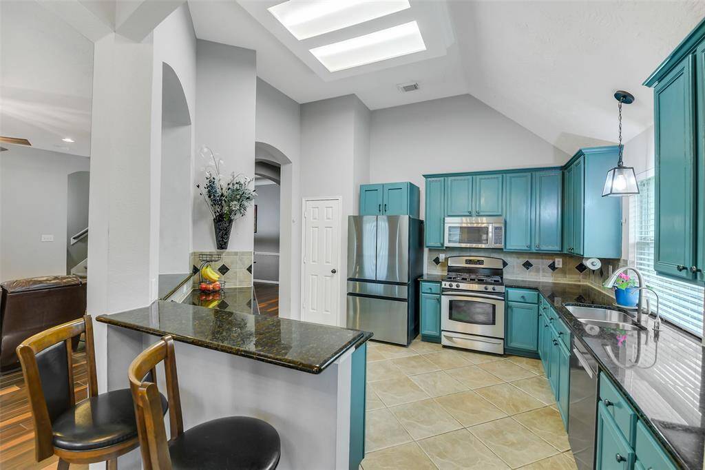 Bar seating and plenty of countertop space and storage in this inviting kitchen!