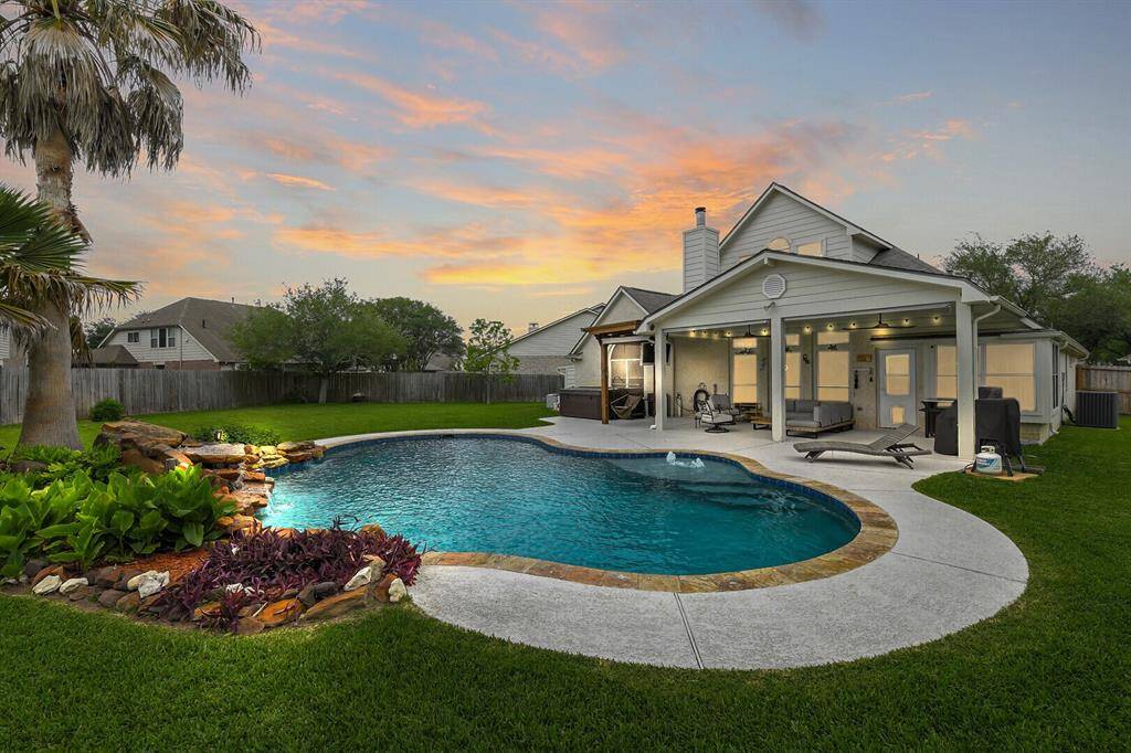 The highlight of this home is the backyard, with the sparkling pool, hot tub, and covered patio on an oversized lot!
