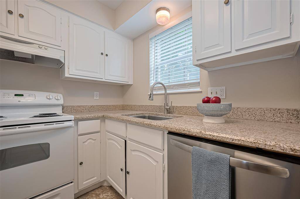 A bright window above the sink offers a lovely view of the front courtyard, bringing in natural light and a peaceful connection to the outdoors.