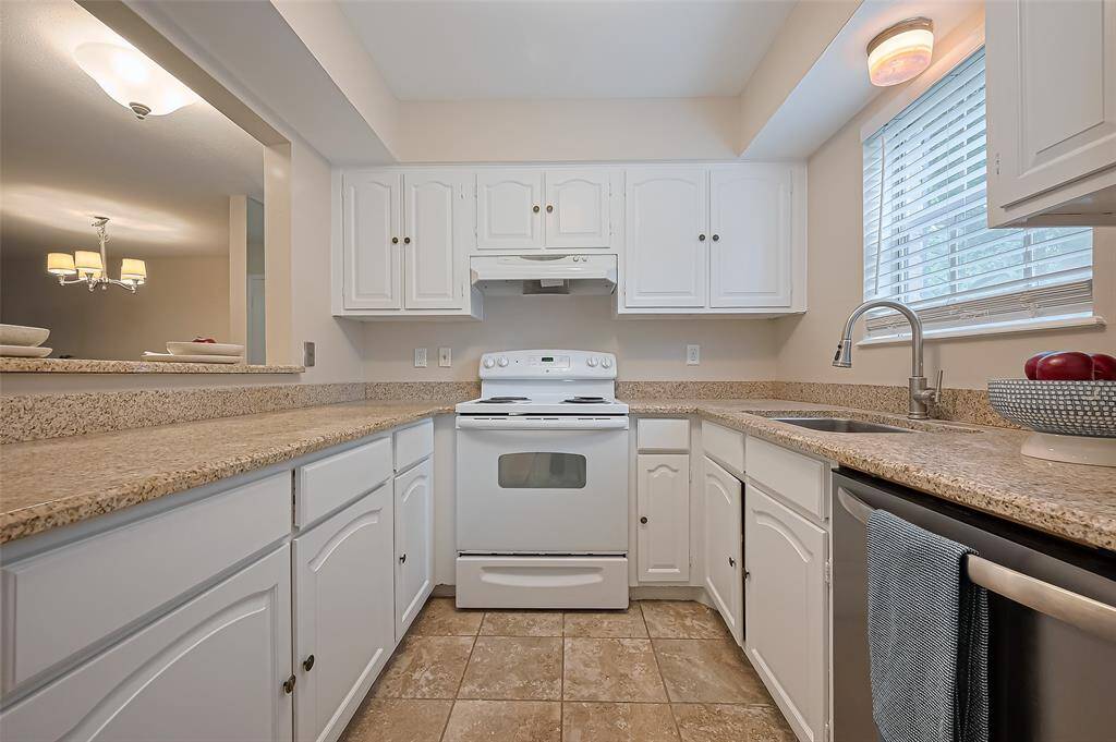 The freshly painted kitchen cabinets offer a crisp, clean look that pairs beautifully with the sleek white range—creating a bright and cohesive cooking space you'll love.