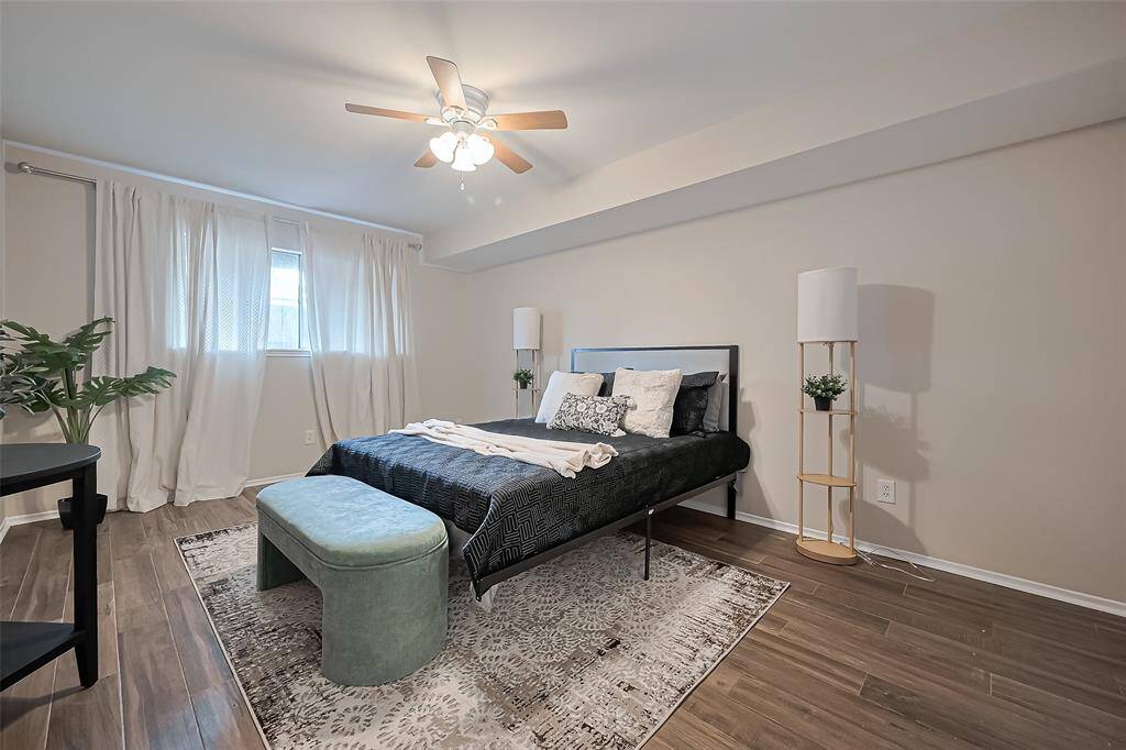 The spacious bedroom offers a peaceful retreat, filled with natural light streaming through the long window—perfect for creating a cozy, sunlit space to unwind.
