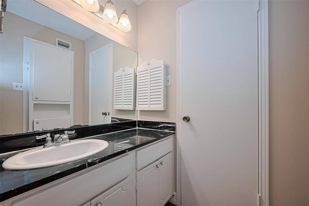 The bathroom offers abundant counter space and plenty of cabinet storage—perfect for keeping everyday essentials neatly organized and within reach.