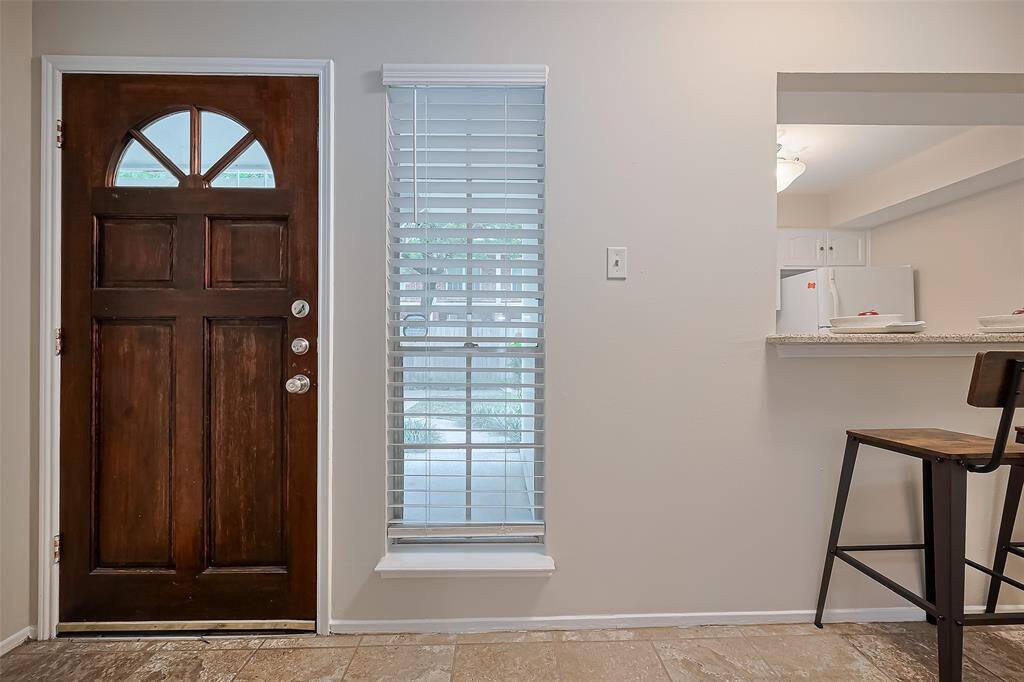 The inviting front door pairs beautifully with the entryway's tall window, offering abundant natural light, and adjustable shades for privacy.