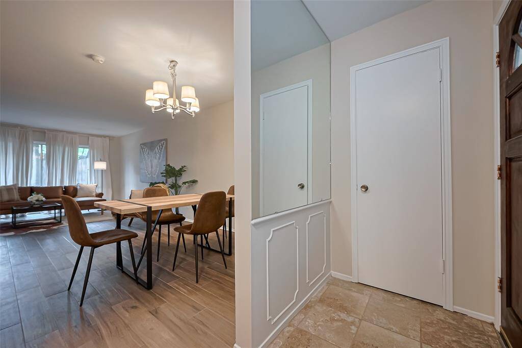 The entryway features a sleek mirrored wall, a convenient coat closet, and stylish tile flooring—creating a polished and practical first impression as you step inside.