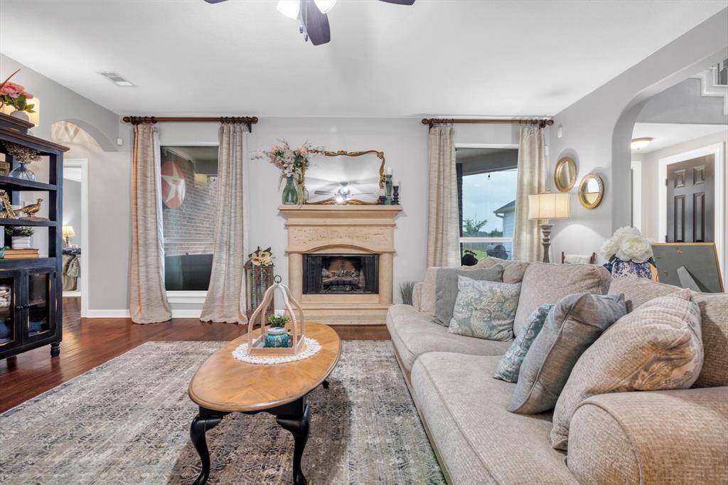 Large living room with gas log fireplace. To the right is the stairs, entrance to the back yard, and kitchen.