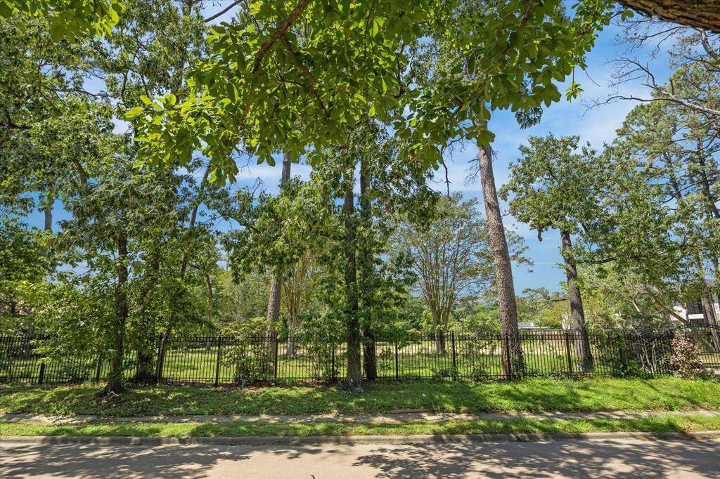 Lot features beautiful mature trees - possibilities are endless with plenty of space for a custom home,pool, circle drive + side driveway, large green space and more.