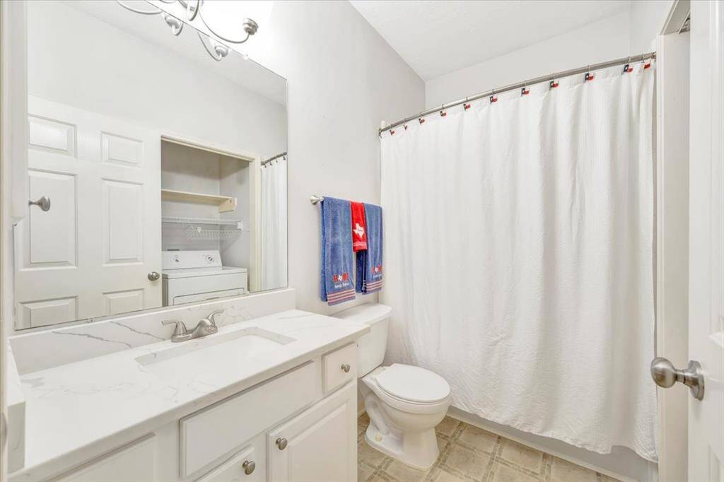 Primary bath with washer and dryer.