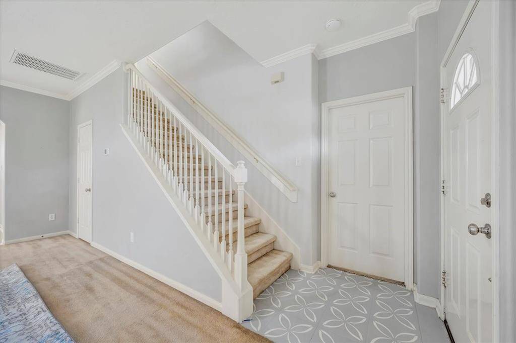 Entry with cute tile leading to upstairs. Door leads to primary suite.