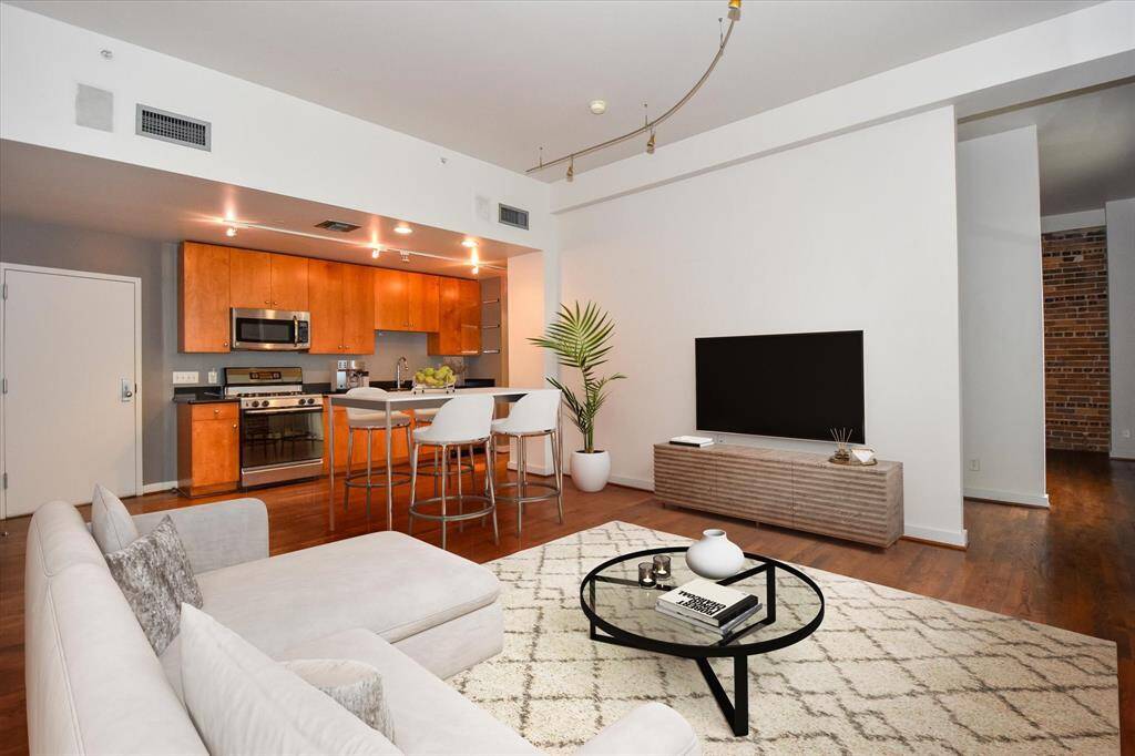 Enjoy effortless flow from the stylish open kitchen into the sunlit living area. Warm wood cabinetry, sleek counters tops, and stainless appliances complement the spacious layout. Perfect for entertaining or relaxing in comfort.