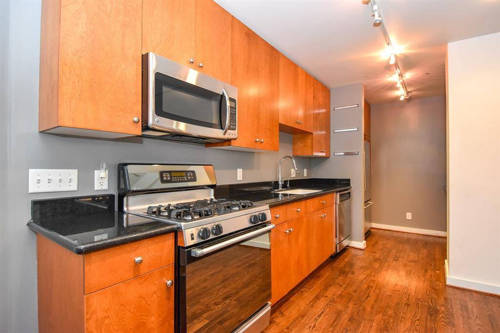 Kitchen featuring a gas stove and oven, surrounded by sleek cabinetry offering plenty of storage.