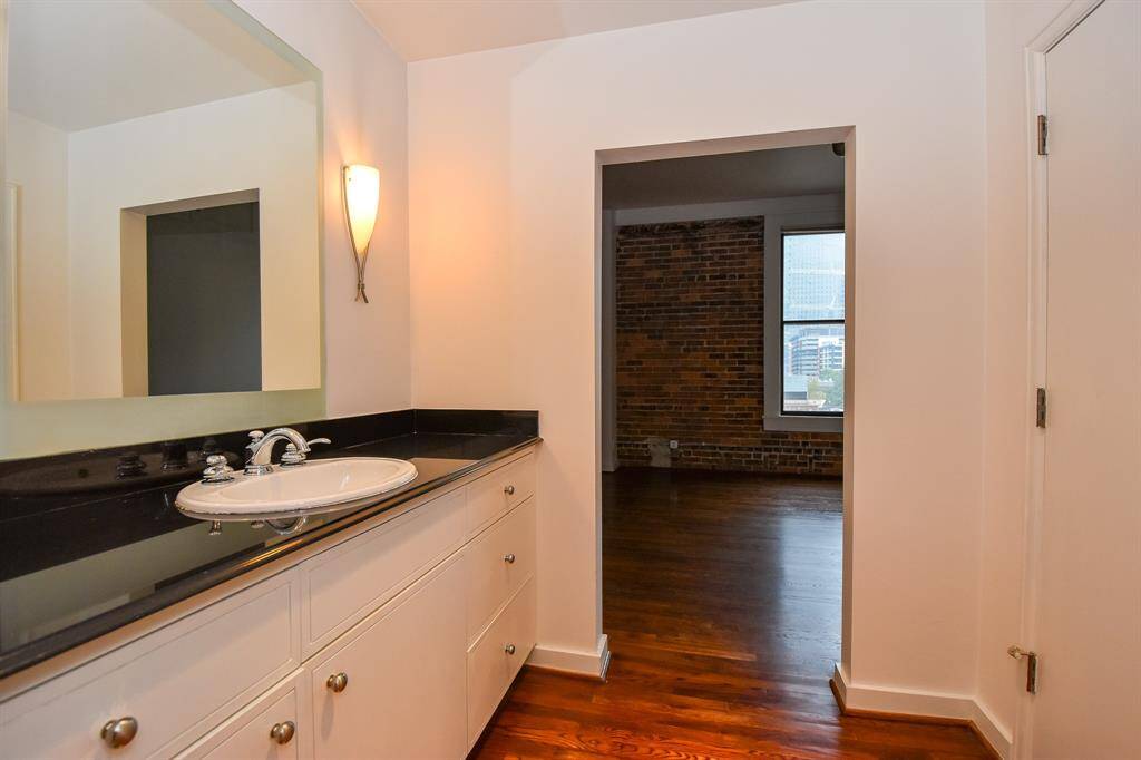 Another view of the primary bathroom, highlighting the sink and mirror from a different angle. This perspective emphasizes the spacious layout.