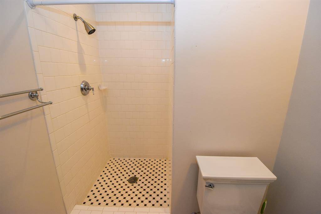 The primary bathroom shower, featuring a sleek and contemporary design with clean lines and high-quality finishes.
