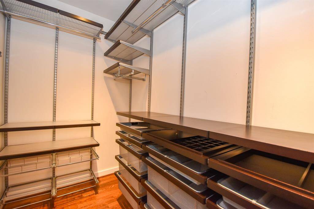 Another view of the walk-in closet, showcasing shelving and hanging space. This spacious and well-organized closet provides ample storage, making it easy to keep everything neatly arranged.