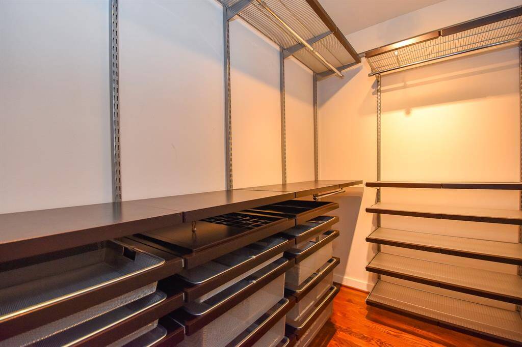 The remodeled primary bedroom closet, featuring custom shelving and hanging racks, offers plenty of storage space and organization.