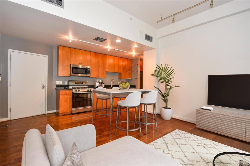 Blending the kitchen, dining, and living areas, this open loft condo offers a spacious layout perfect for entertaining or relaxing. Wood flooring, and natural light tie the space together beautifully.