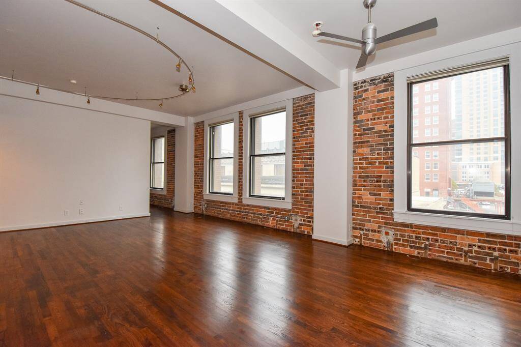 Bright and inviting living area filled with natural light, featuring large windows that showcase stunning Downtown Houston views. A perfect space to relax or entertain while enjoying the city skyline.