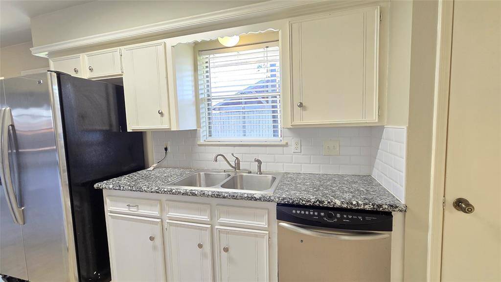 The kitchen boasts beautiful granite countertops, with natural light pouring in through the window. The sinks are perfectly positioned for convenience, making meal prep a breeze.