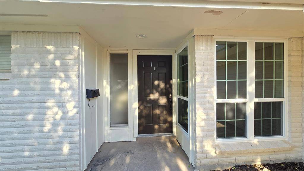 A warm welcome awaits with a modern black front door, large windows pouring in natural light, and crisp light brick that adds timeless curb appeal.