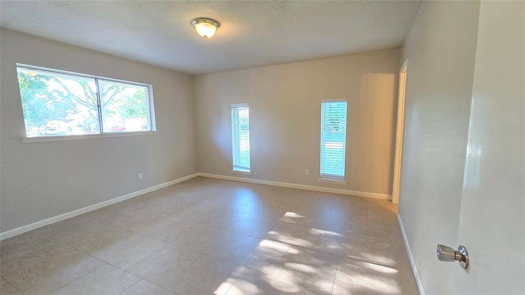 The spacious owner's suite is filled with natural light from three large windows—one picture window overlooking the driveway and two with serene views of the front yard.