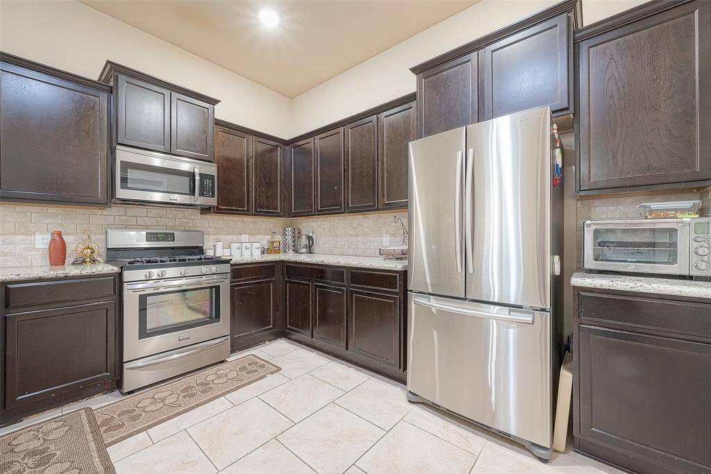 Rich dark brown cabinets with a sleek backsplash adds the perfect touch!