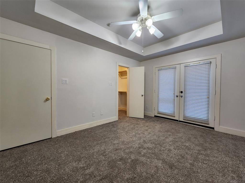 4th bedroom with double doors open to the backyard and patio
