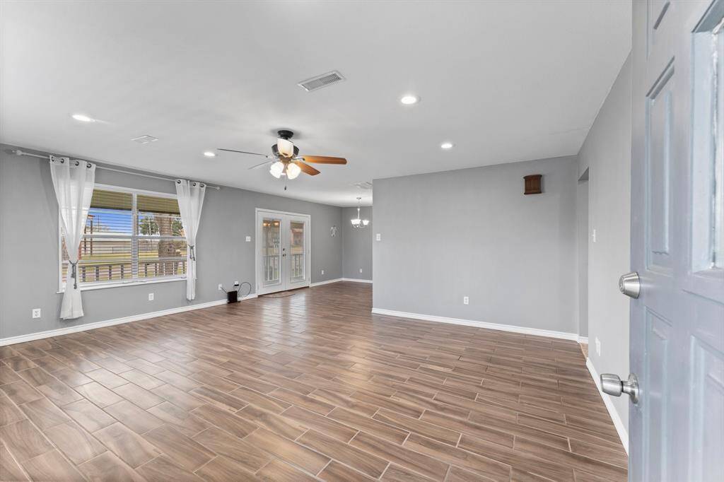 This home features a wraparound porch, well-maintained lawn, and mature trees.