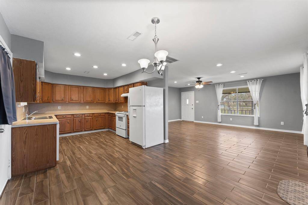 This room features a spacious, open layout with ample natural light from large windows. French doors lead to an outdoor area, and the neutral gray walls create a modern and inviting atmosphere.