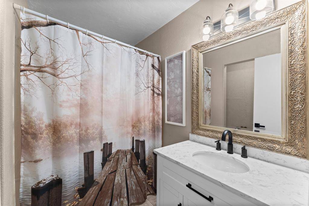 This bedroom features neutral walls, carpeted flooring, and a ceiling fan with lights.