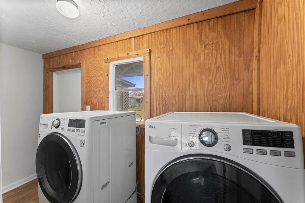 This room features a ceiling fan and a large window offering ample natural light. It has wood-look flooring and neutral walls, providing a clean and modern look.