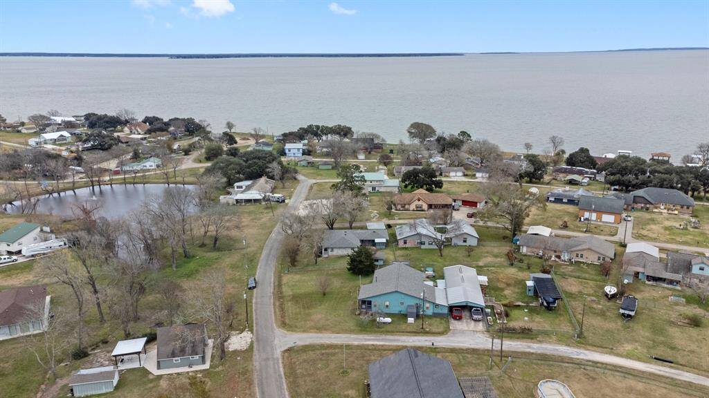 This aerial photo shows a peaceful lakeside neighborhood with open green spaces, and tree-lined streets. The lake provides scenic views, adding to the suburban charm.