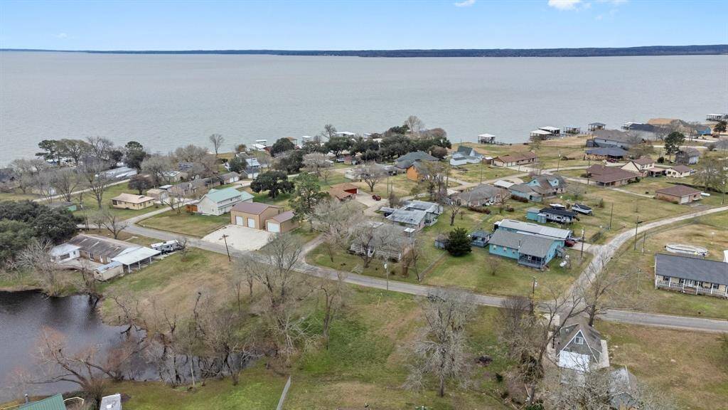 Aerial photo shows a lakeside community. The neighborhood is nestled near Lake Livingston, offering scenic views and a relaxed atmosphere ideal for a tranquil lifestyle.