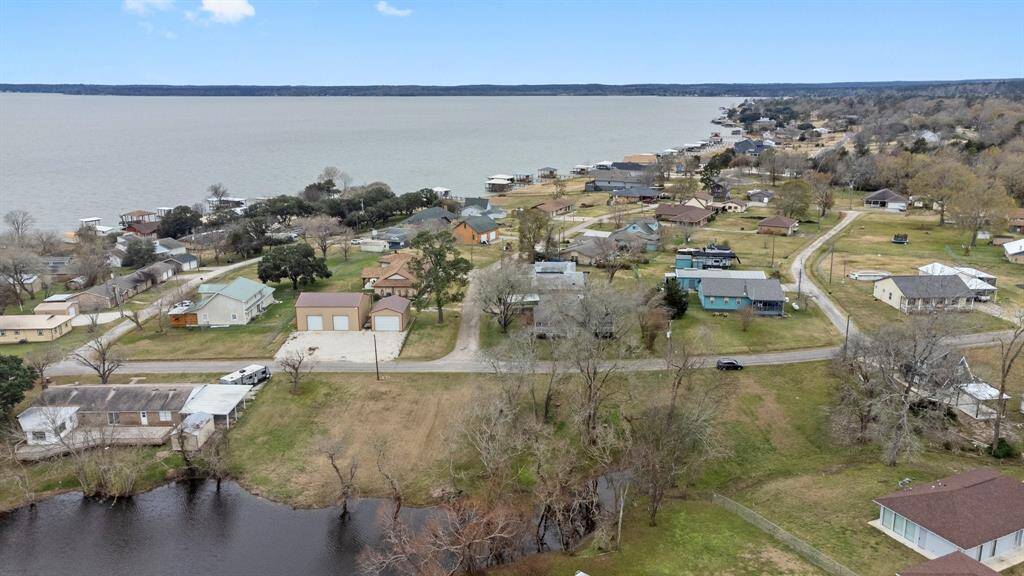 Aerial photo shows a lakeside community. The neighborhood is nestled near Lake Livingston, offering scenic views and a relaxed atmosphere ideal for a tranquil lifestyle.