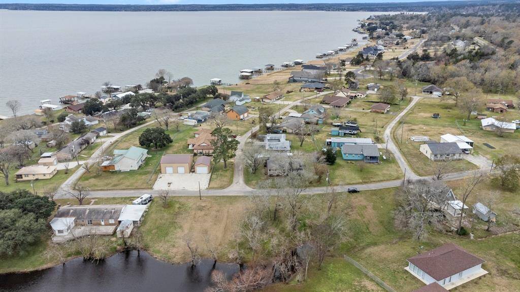 Aerial photo shows a lakeside community. The neighborhood is nestled near Lake Livingston, offering scenic views and a relaxed atmosphere ideal for a tranquil lifestyle.