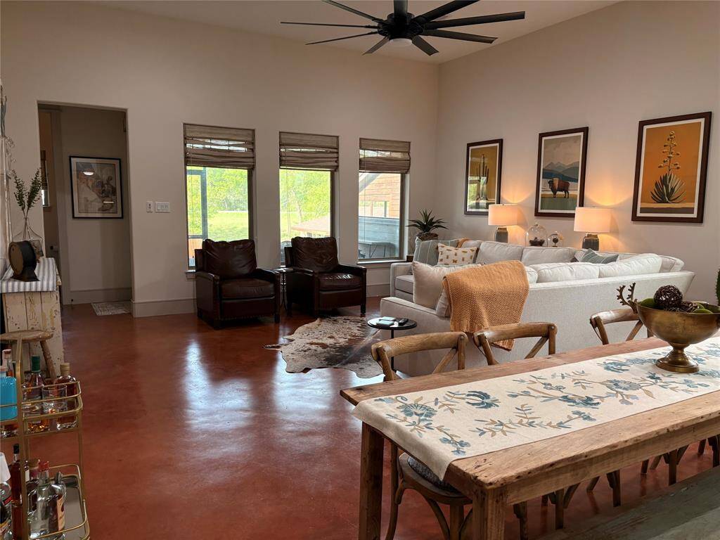 Here's a full view of the large living area. Three large windows overlook the screen porch, deck, and yard. To the left of room is the door leading to the screen porch, straight ahead is the powder room, and to the left is the primary bedroom.