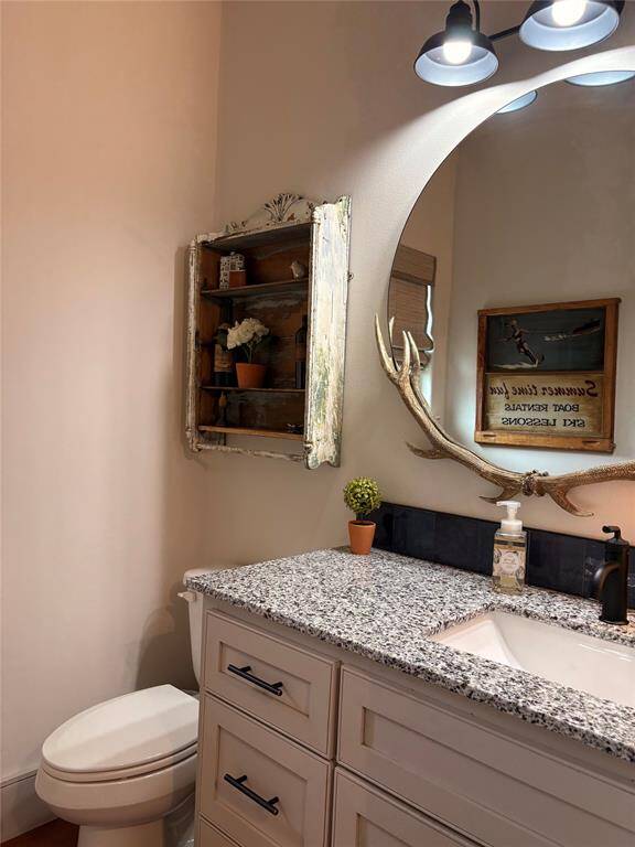 Throughout the house the custom builders maintained the beautiful woodwork with custom cabinets with soft close cabinets and drawers in all the bathrooms. This is the powder room that's conveniently located off the main living area.