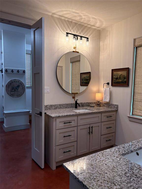 One of the custom vanities that can accommodate all your toiletries. Beautiful granite, fixtures, and mirrors make this bathroom special.