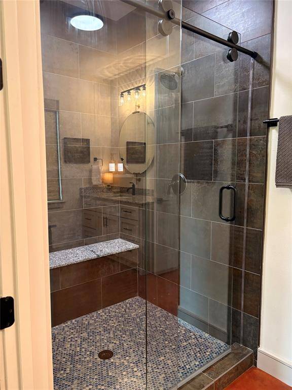 A large walk in shower with a sliding door is the final touch on this beautiful primary bathroom.