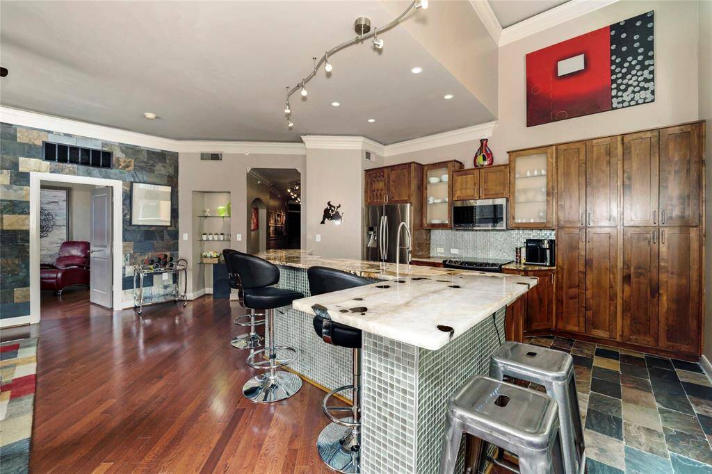 The living room seamlessly opens up to the kitchen and the entry to the primary bedroom is on the left.